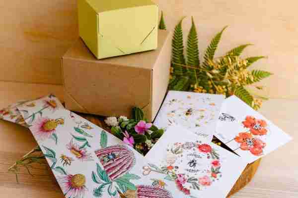 Nina's Bees gift wrapping with botanical belly wrap featuring bees and clover, accompanied by a floral card