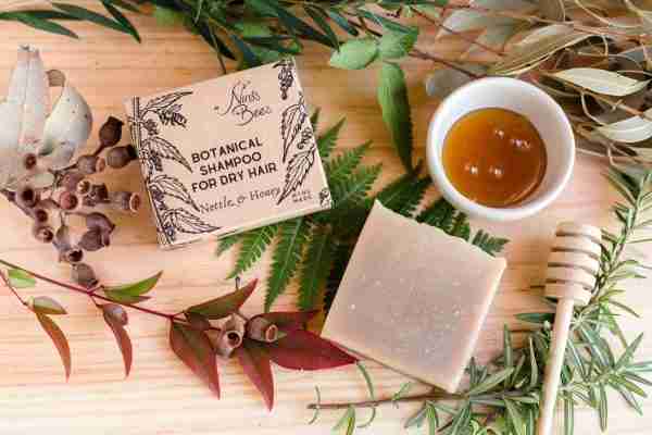 Solid nettle and rosemary shampoo bar for strong, glossy hair on natural bathroom background
