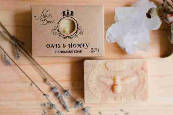 Box of Nina’s Bees Oats & Honey Handmade Soap displayed on a wooden surface with dried botanicals, crystals, and natural elements.