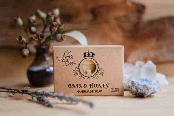 Box of Nina’s Bees Oats & Honey Handmade Soap displayed on a wooden surface with dried botanicals, crystals, and natural elements.