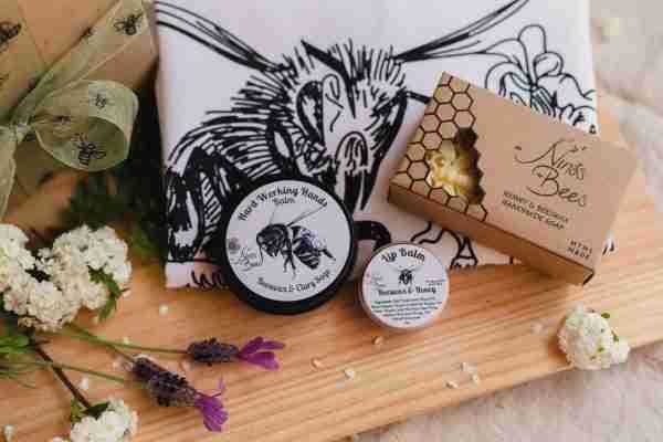 Eco-friendly gift pack featuring a linen “Bees Love My Garden” tea towel with bee artwork, natural honey soap, nourishing lip balm, and botanical Hard Working Hands Balm, beautifully packaged for gardeners, bee lovers, and nature enthusiasts.