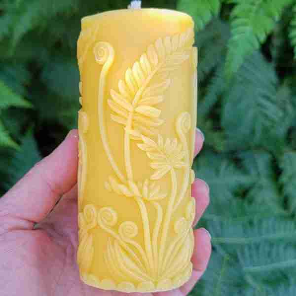 beeswax candle adorned with fern pattern